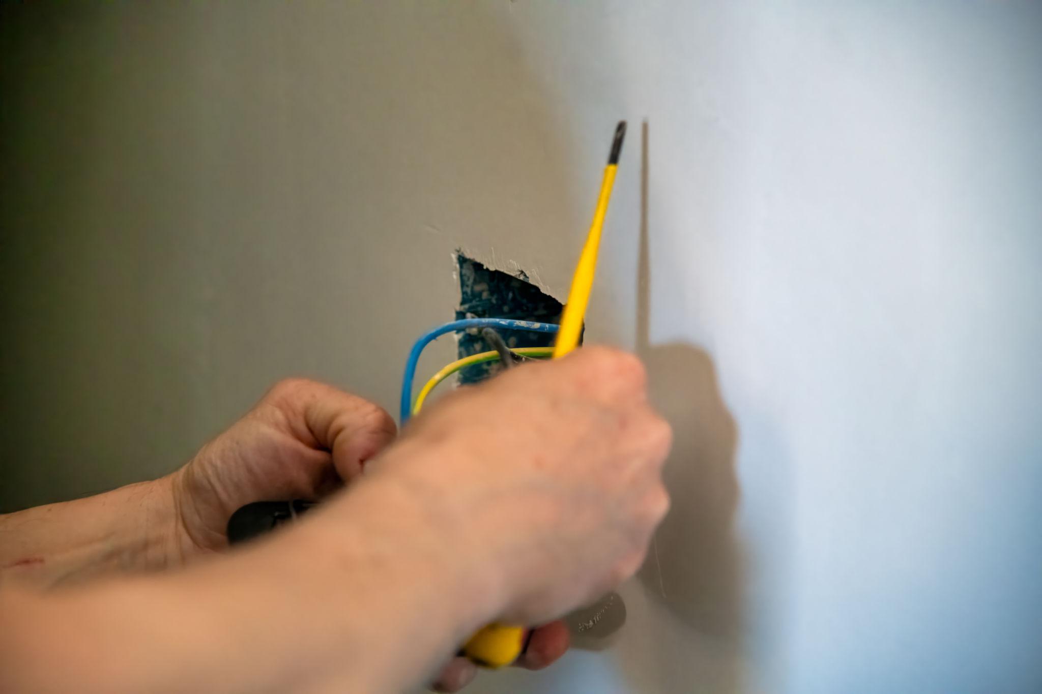 Elektriker bei der Neuinstallation im Rohbau